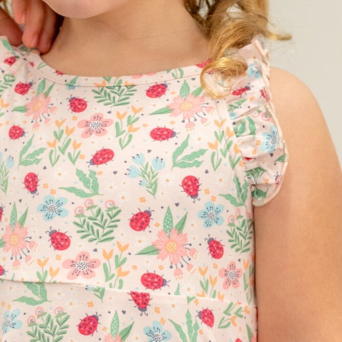 Girls’ racerback dress neckline with ladybug, flower, and leaf print; ruffled strap
