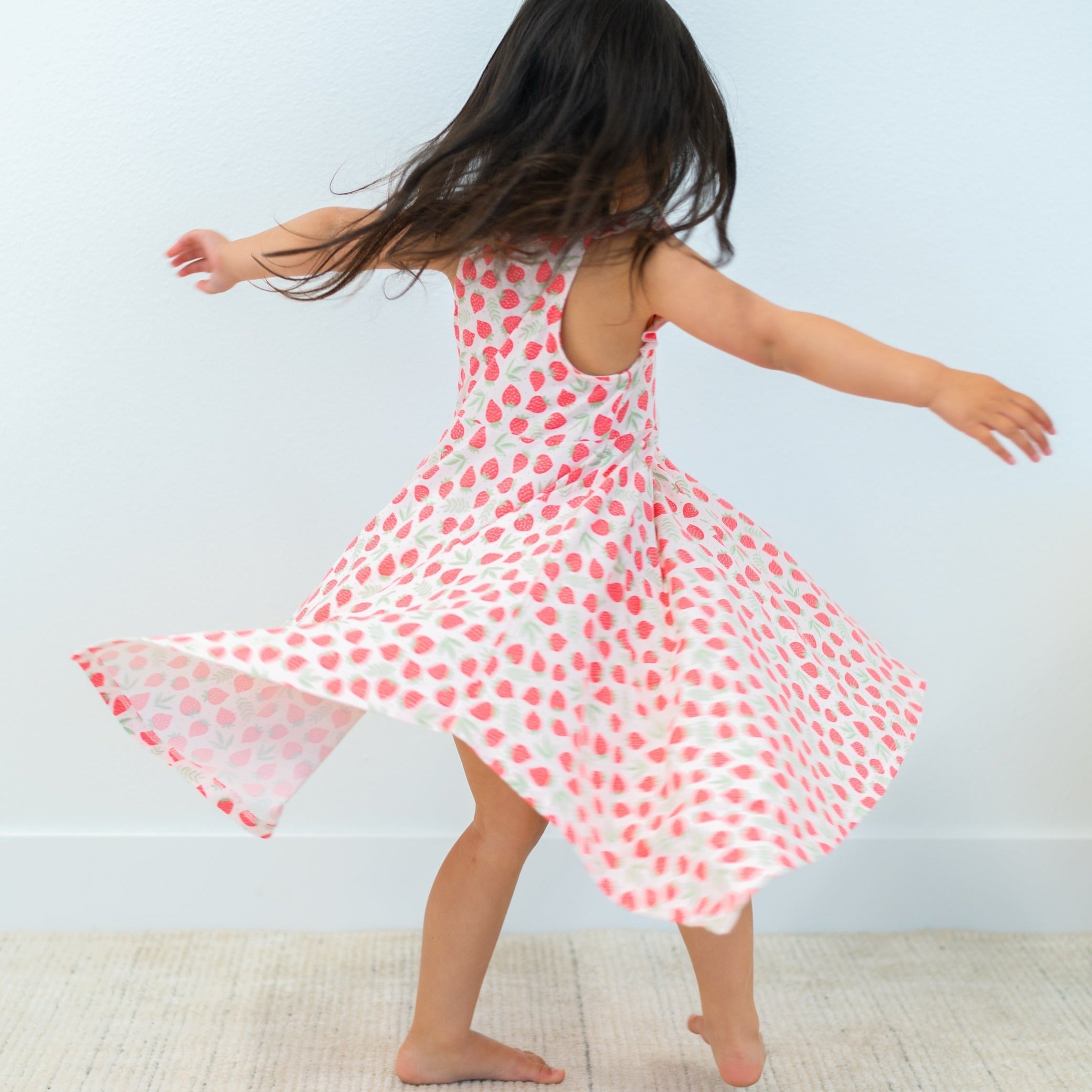 Open-back racerback dress with pink strawberry print and wide flared hem