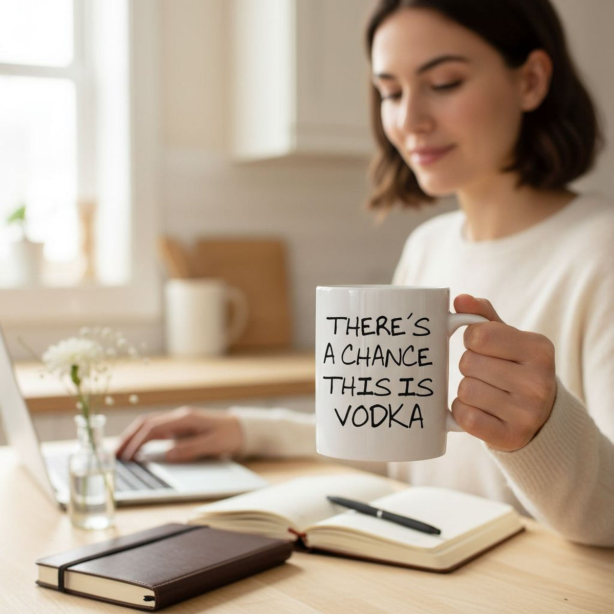 White coffee mug with 'THERE'S A CHANCE THIS IS VODKA' lettering, held in hand