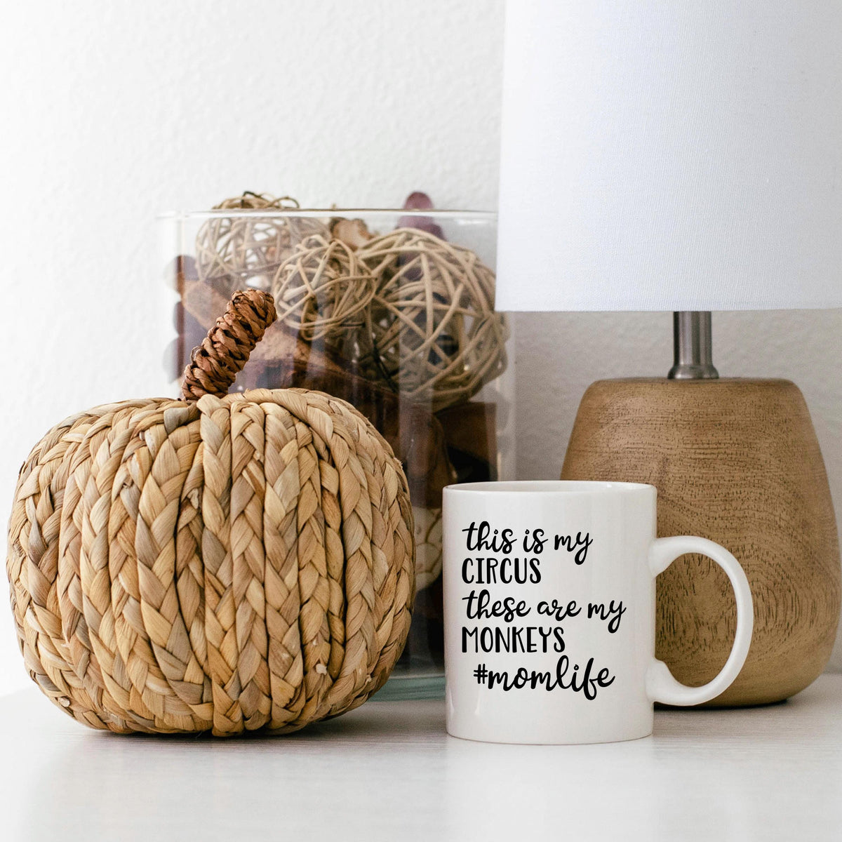 White ceramic coffee mug with "Circus" momlife message beside home decor