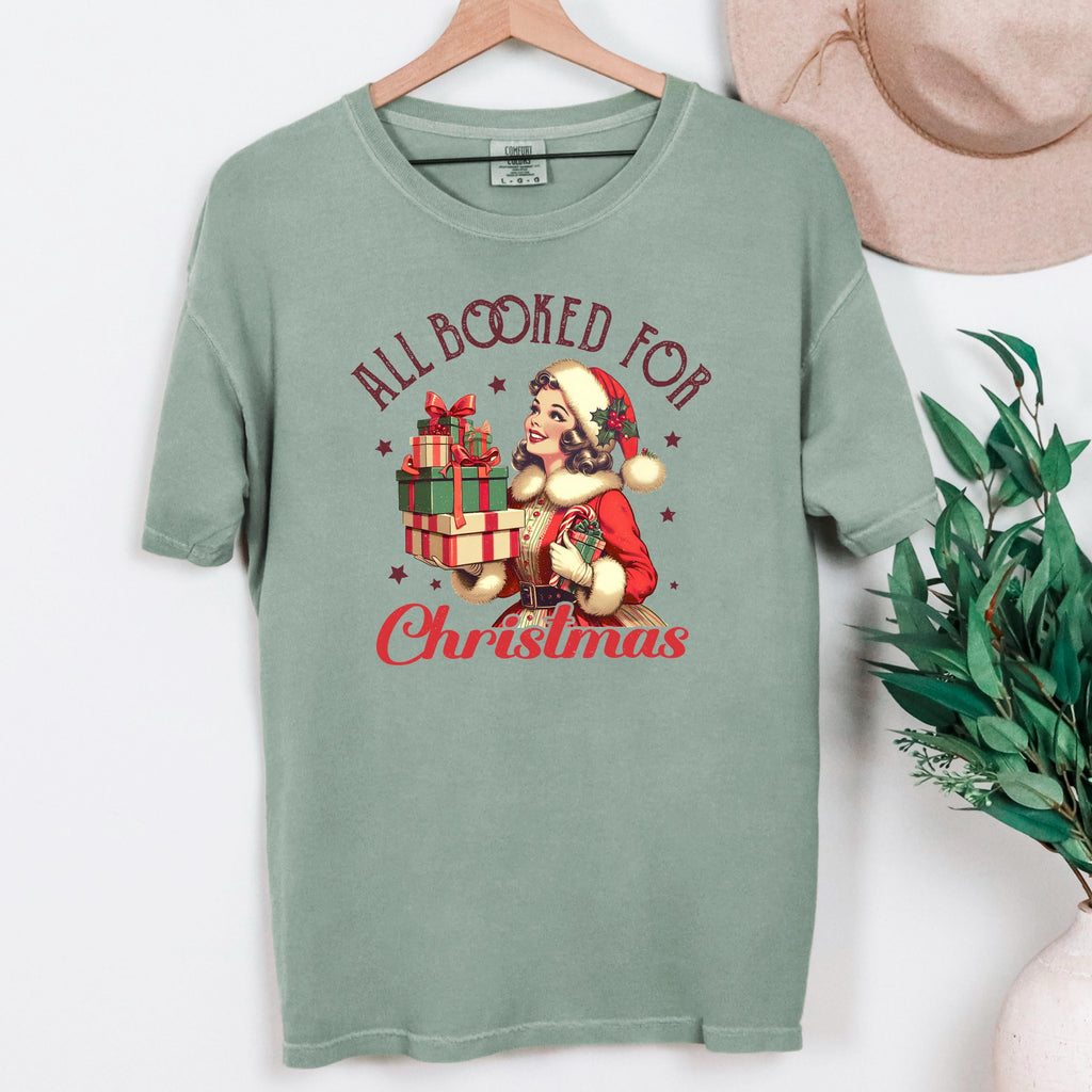 Sage green crewneck Christmas graphic tee hanging on a wooden hanger