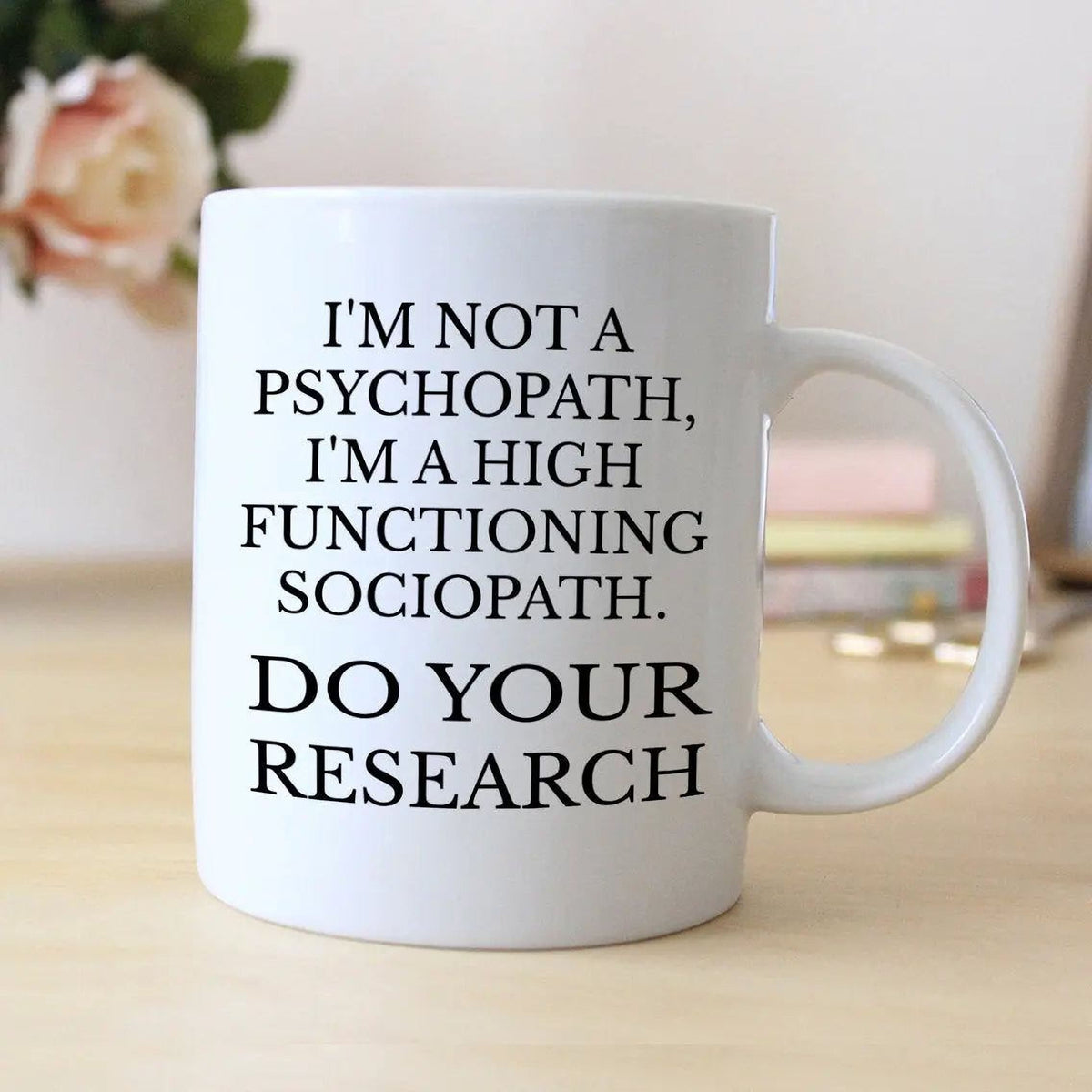 White ceramic coffee mug with black quote: “DO YOUR RESEARCH” and side handle.