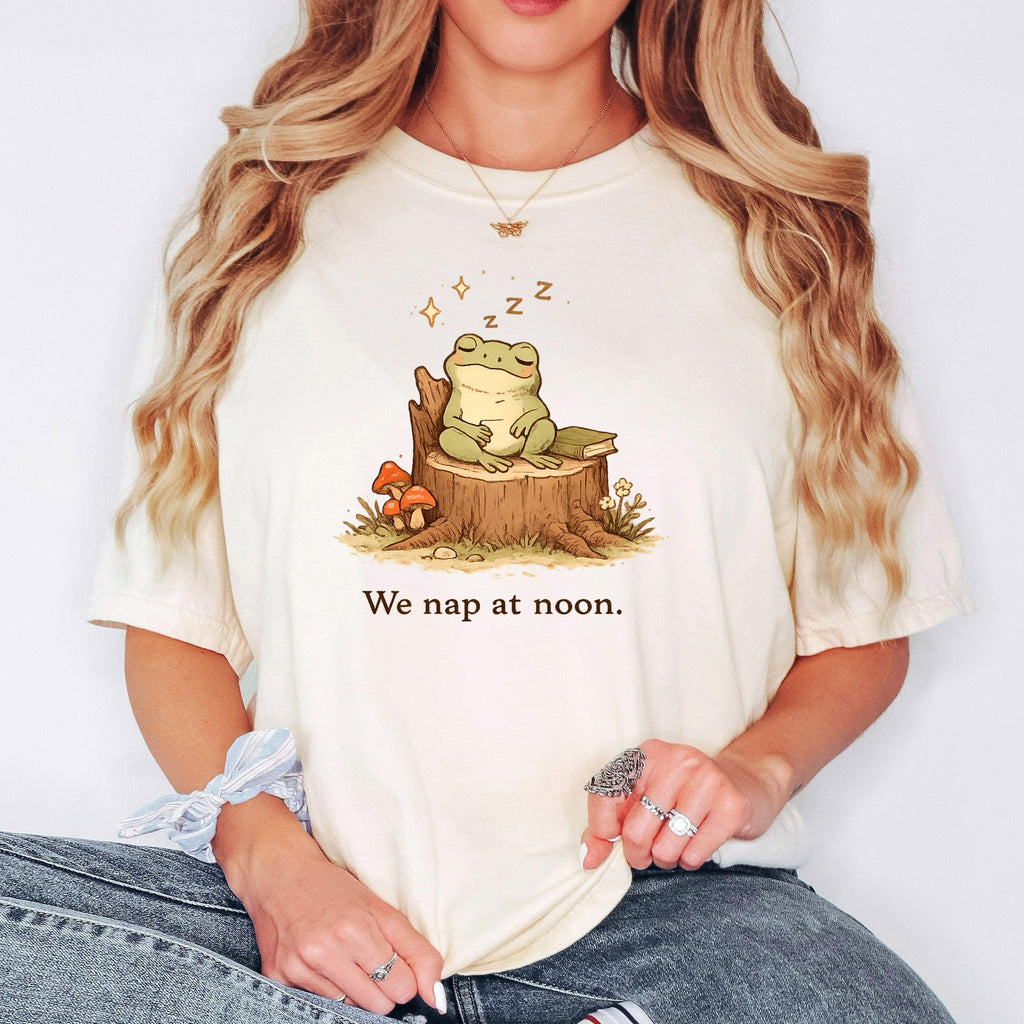 Ivory T-shirt with sleeping frog illustration and “We nap at noon.” lettering.