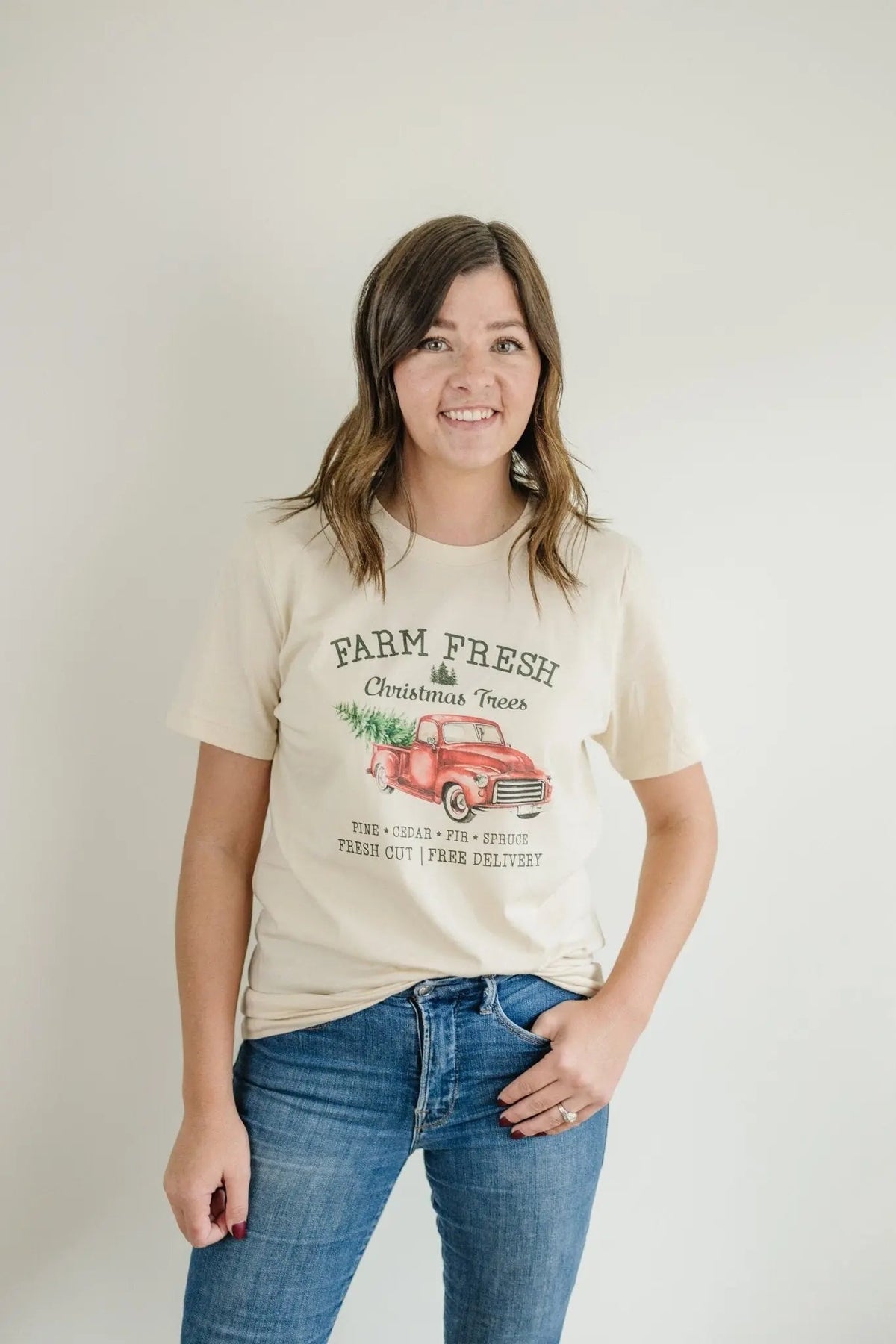 Cream T-shirt on model with Farm Fresh Christmas Trees red truck graphic