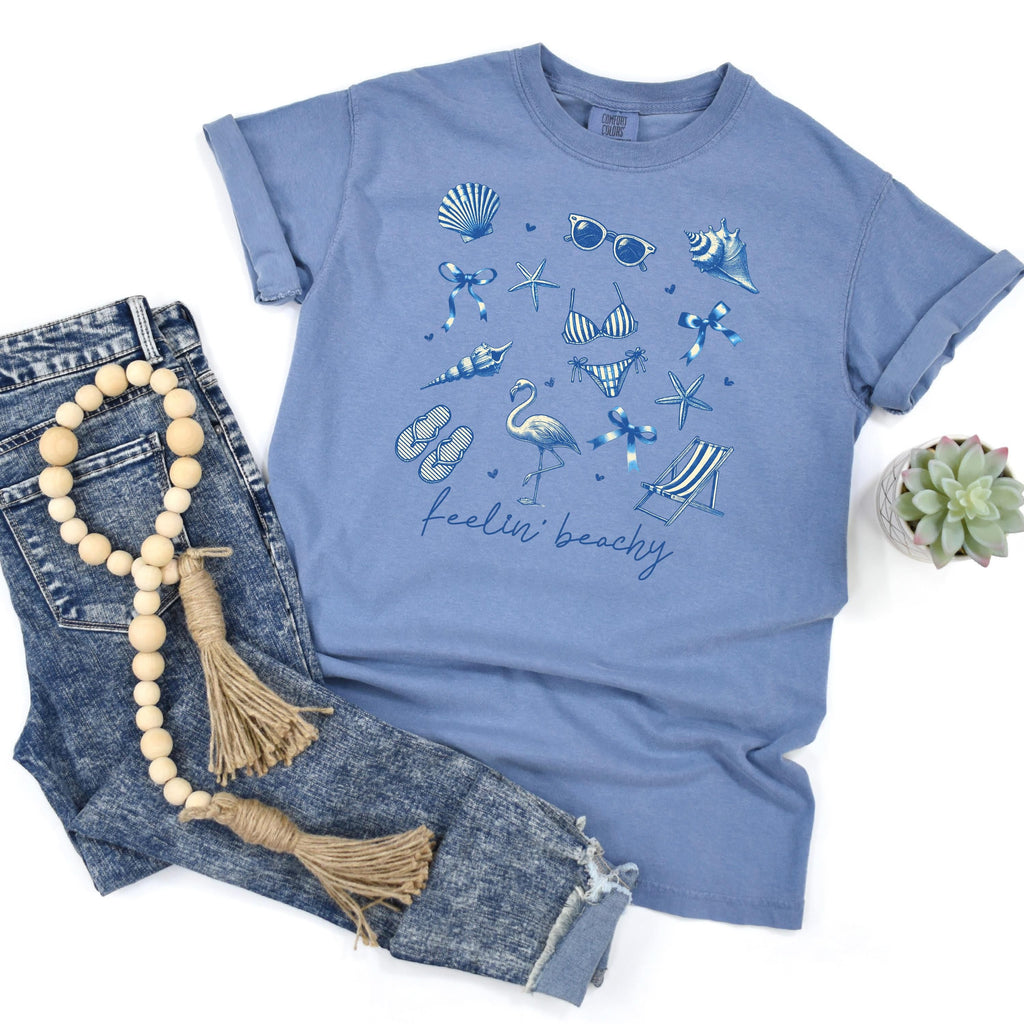 Blue jean unisex beach graphic tee with blue shells and “feelin’ beachy” print