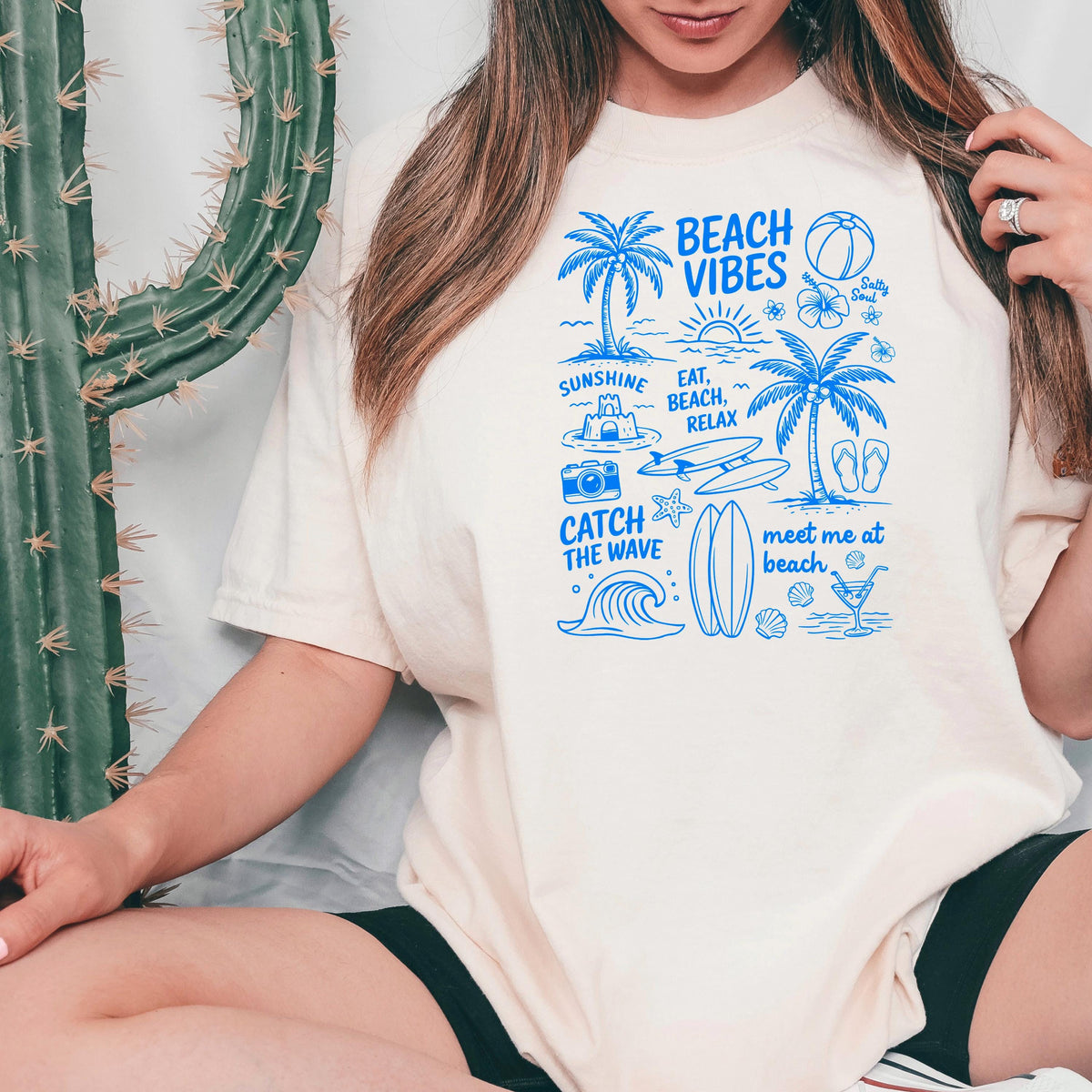 Ivory women’s T-shirt with blue “Beach Vibes” graphic on the front