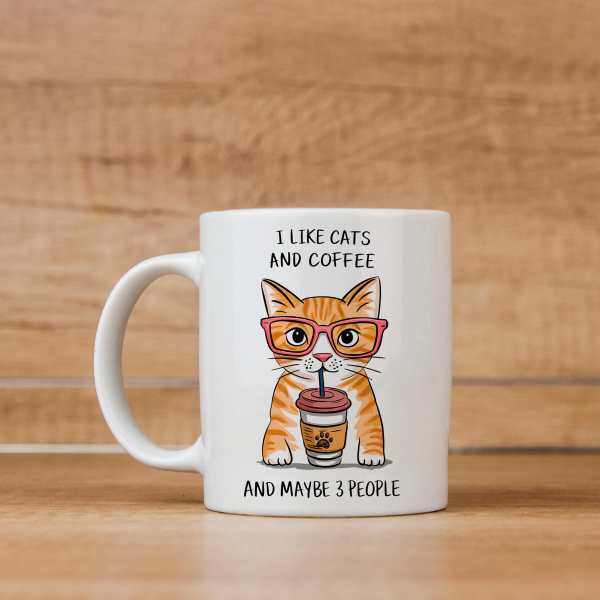 White ceramic mug with orange tabby cat holding a coffee cup graphic