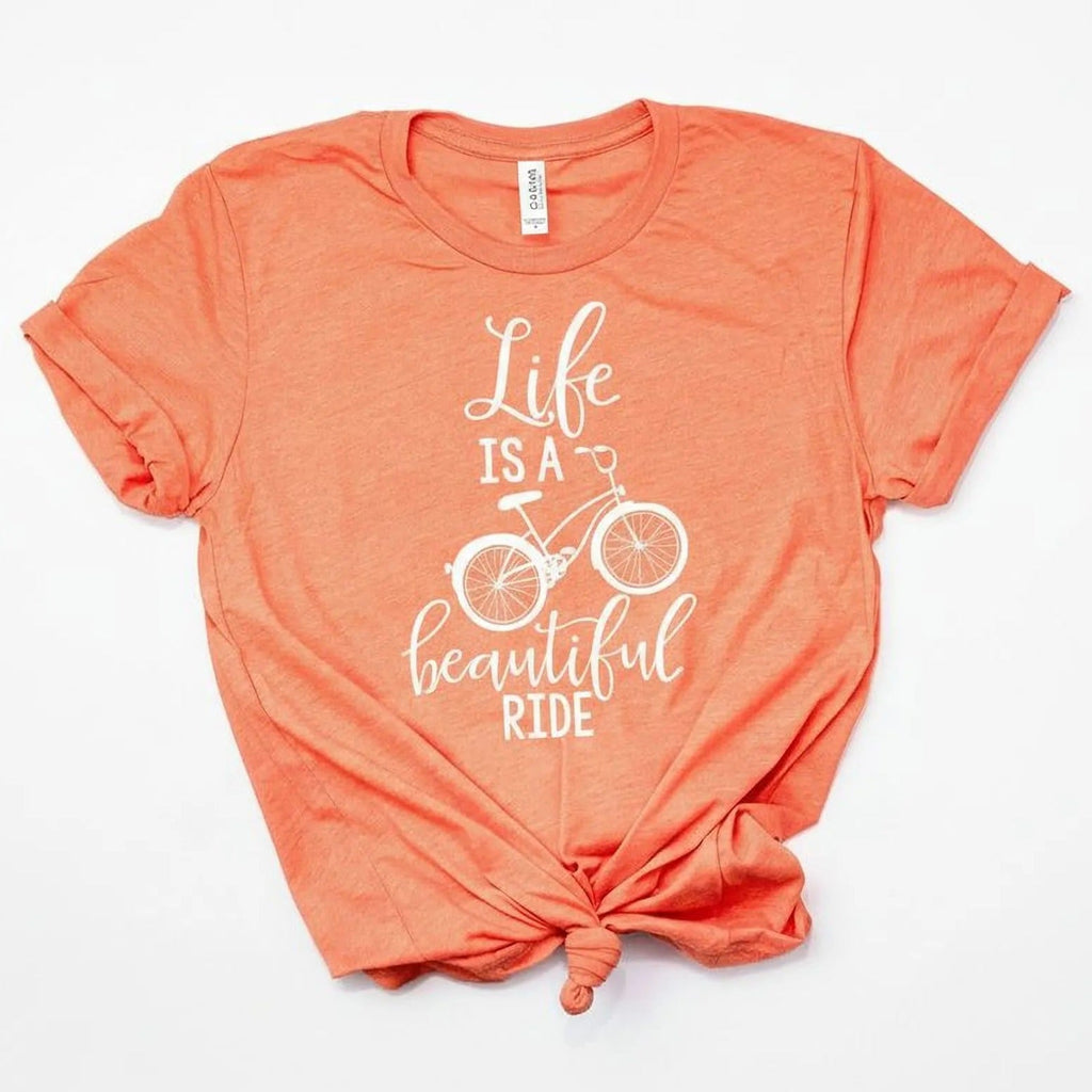 Coral unisex graphic bicycle quote T-shirt with white “Life is a beautiful ride” front
