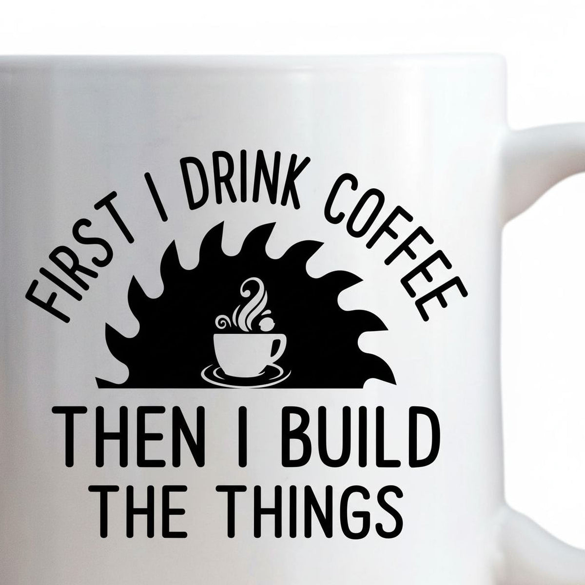 Close-up of white ceramic mug showing black “First I drink coffee, then I build the things” design