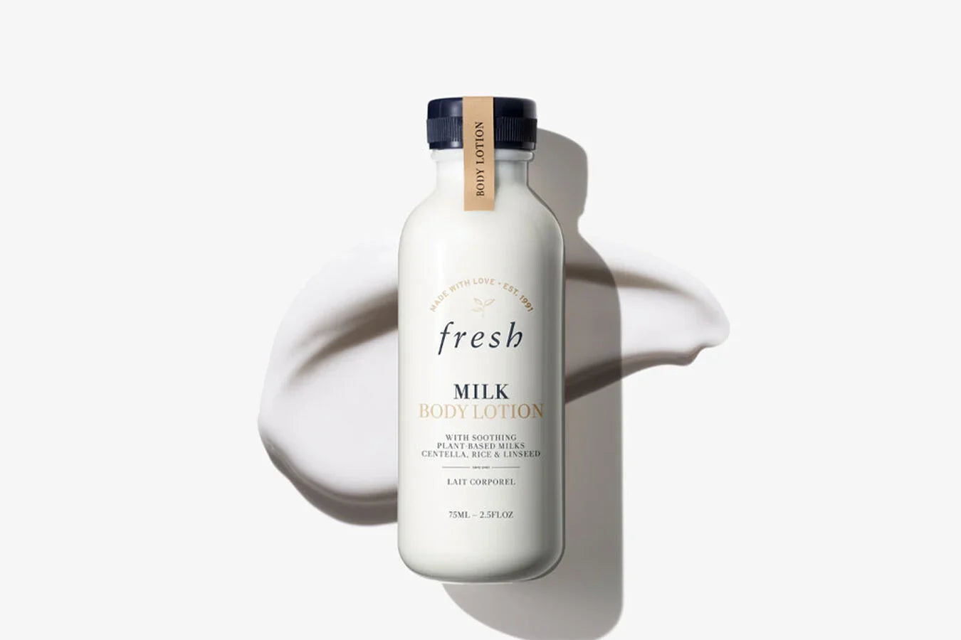 Milk body lotion bottle with dark blue cap and beige label on white bottle