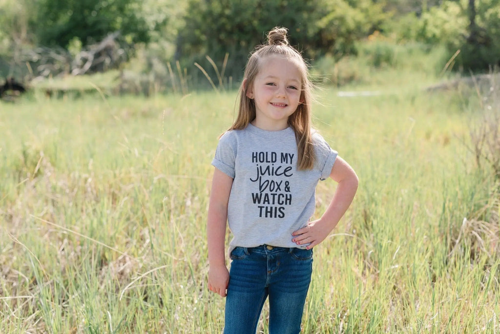 Gray toddler T-shirt with "Hold my juice box and watch this" text, front view