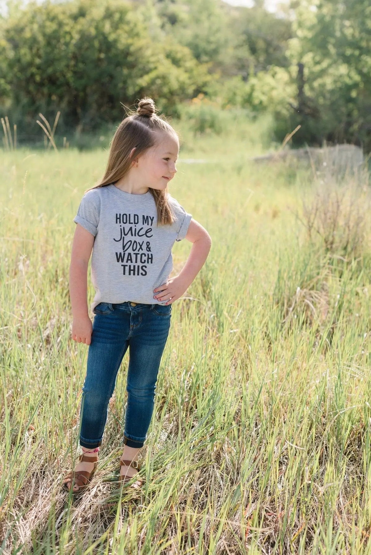 Gray toddler T-shirt with "Hold my juice box and watch this" text, side view