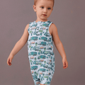 Sleeveless romper with white base and green/blue truck print, worn by baby