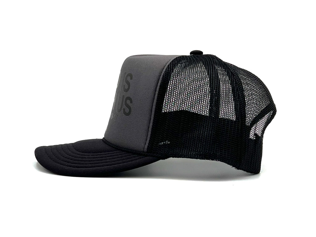 Charcoal foam trucker cap with black mesh panels and curved brim; side lettering visible.