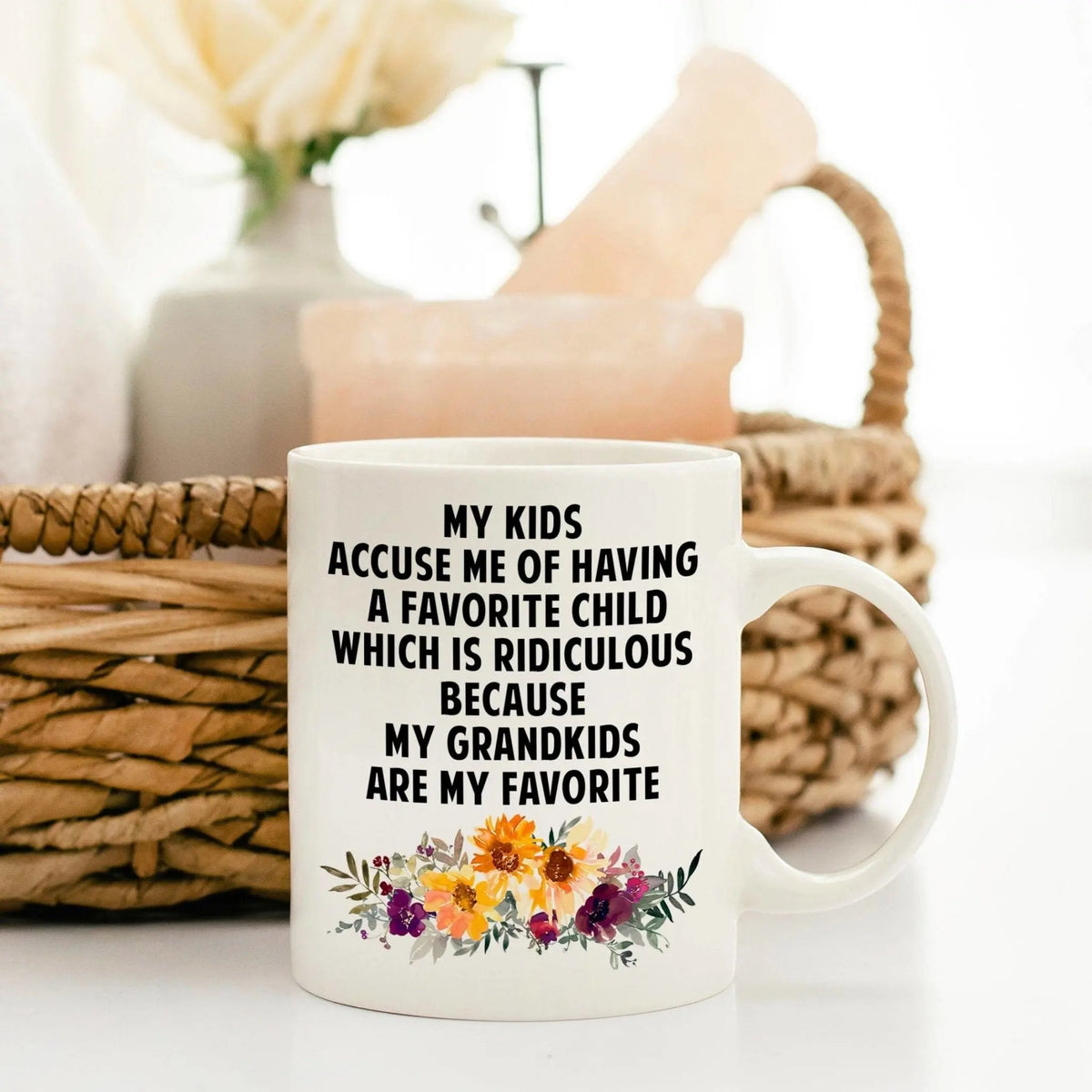 White ceramic mug with bold text and colorful floral bouquet near the bottom.