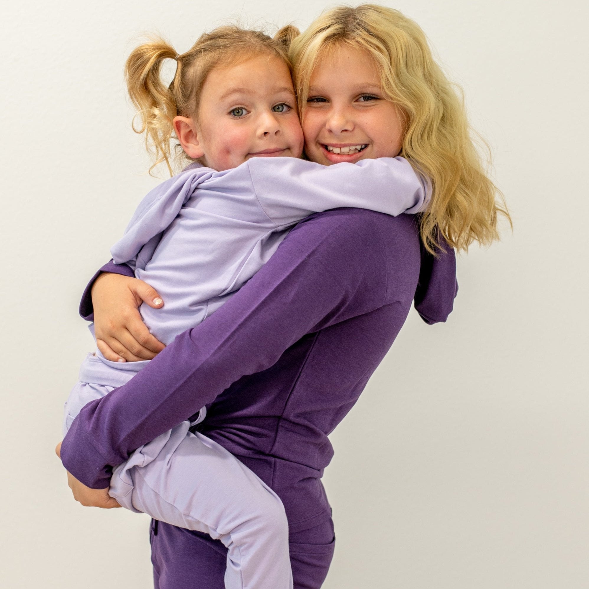 Kids hooded jogger set in dark purple with light purple joggers, matching hooded tops