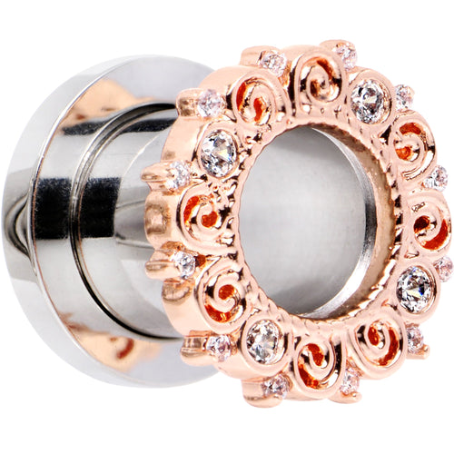 Rose-gold ear tunnel plug with ornate circular filigree and clear gem stones