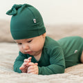 Hunter green long-sleeve bodysuit on baby, snug fitted knit
