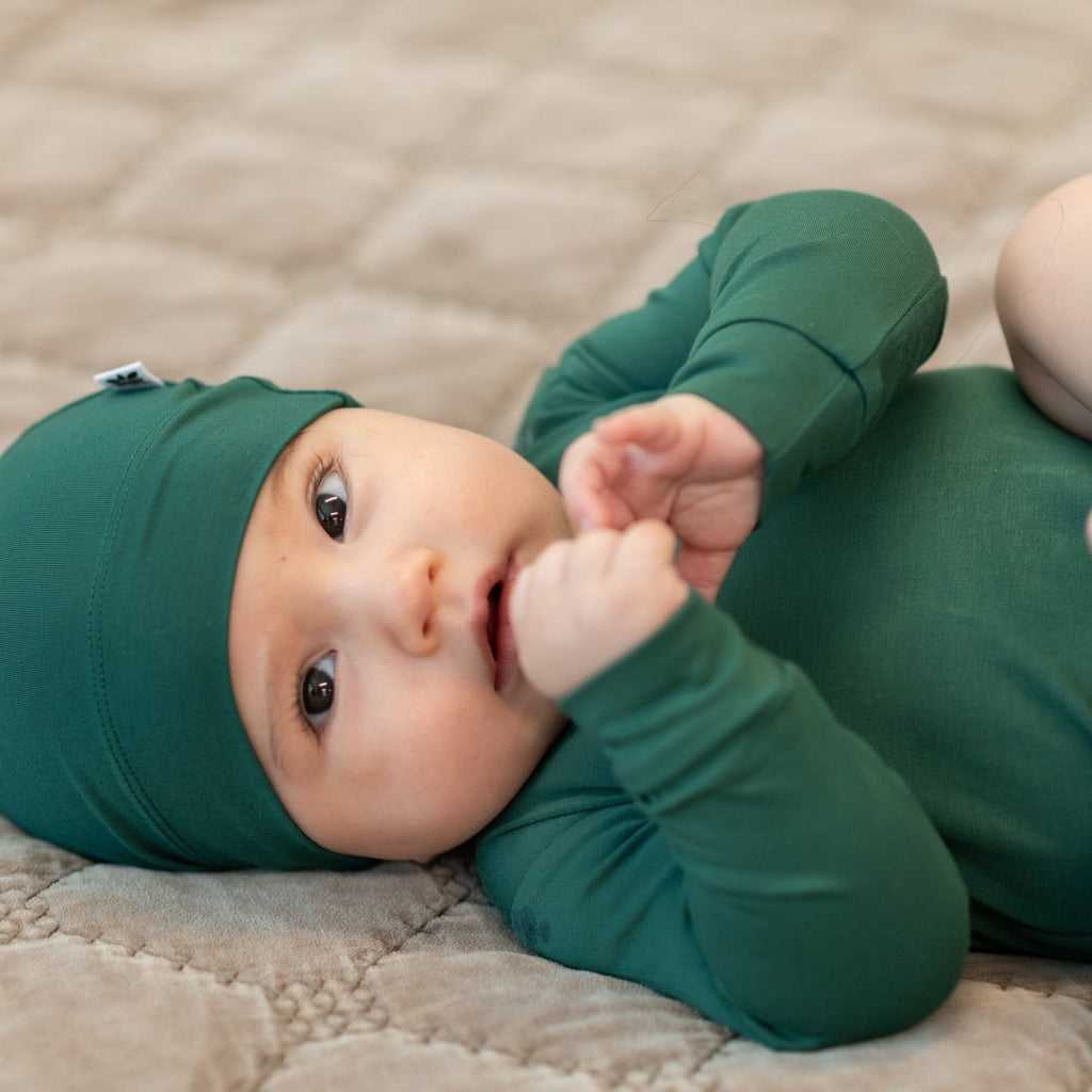 Hunter green long-sleeve bodysuit on baby, close-up of sleeves and neckline