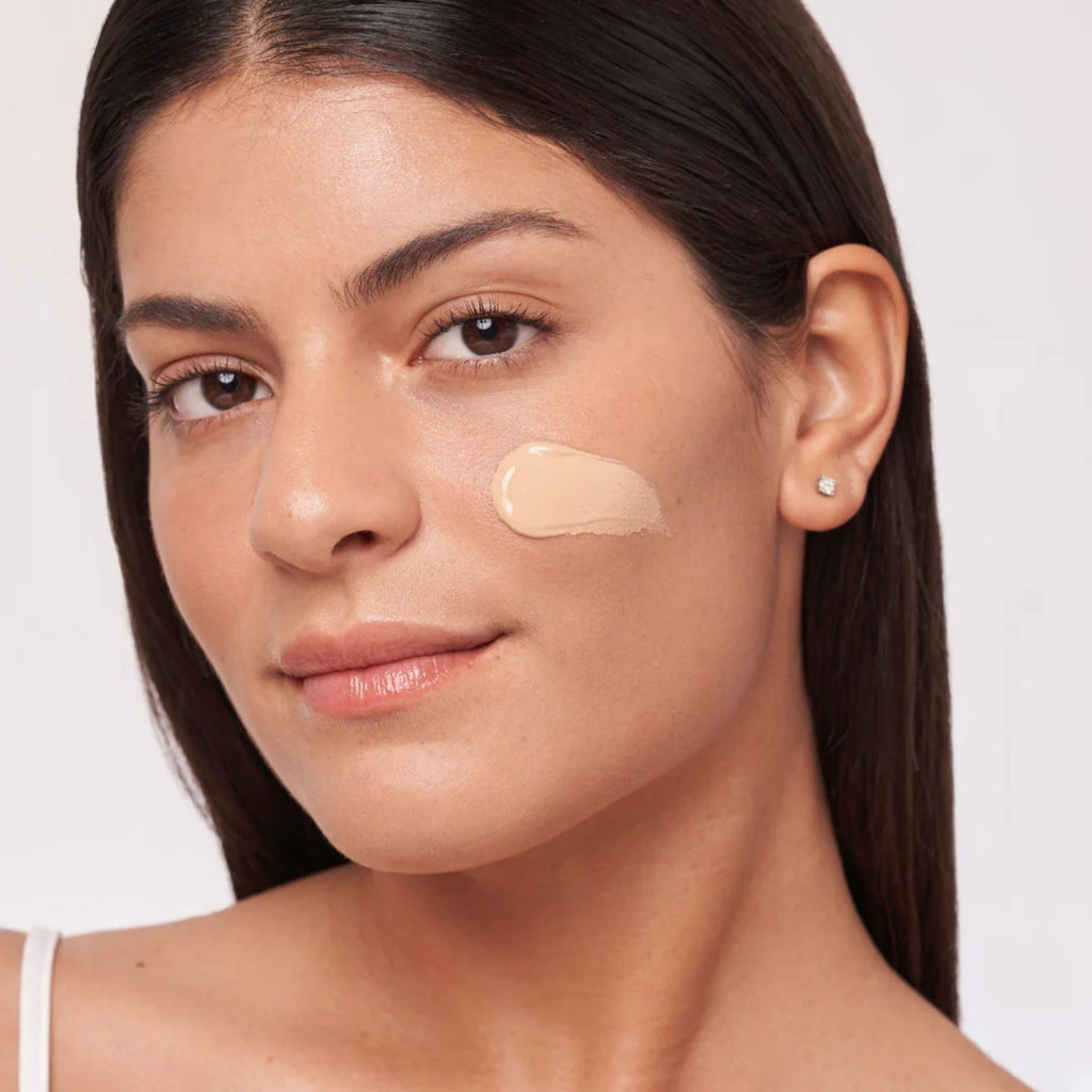 Tinted sunscreen applied on cheek and forehead on a woman's face