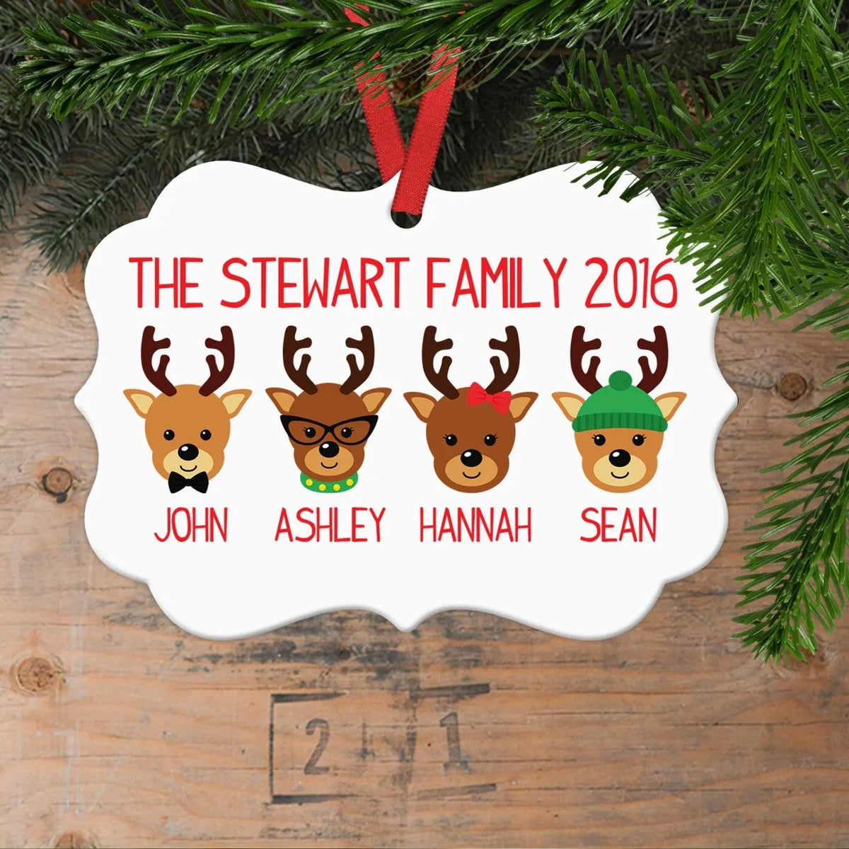 White reindeer family ornament with four reindeer portraits and red ribbon loop