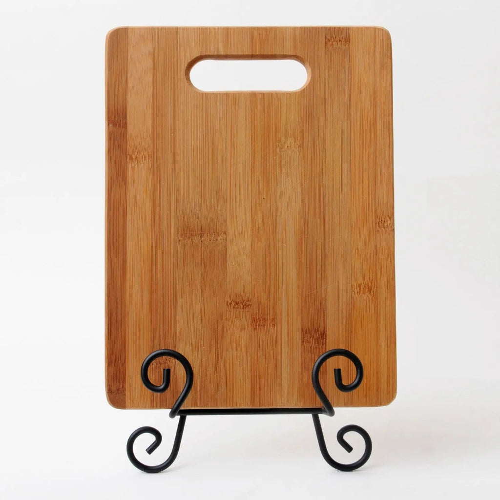 Bamboo cutting board back view with handle slot and scroll feet display stand.