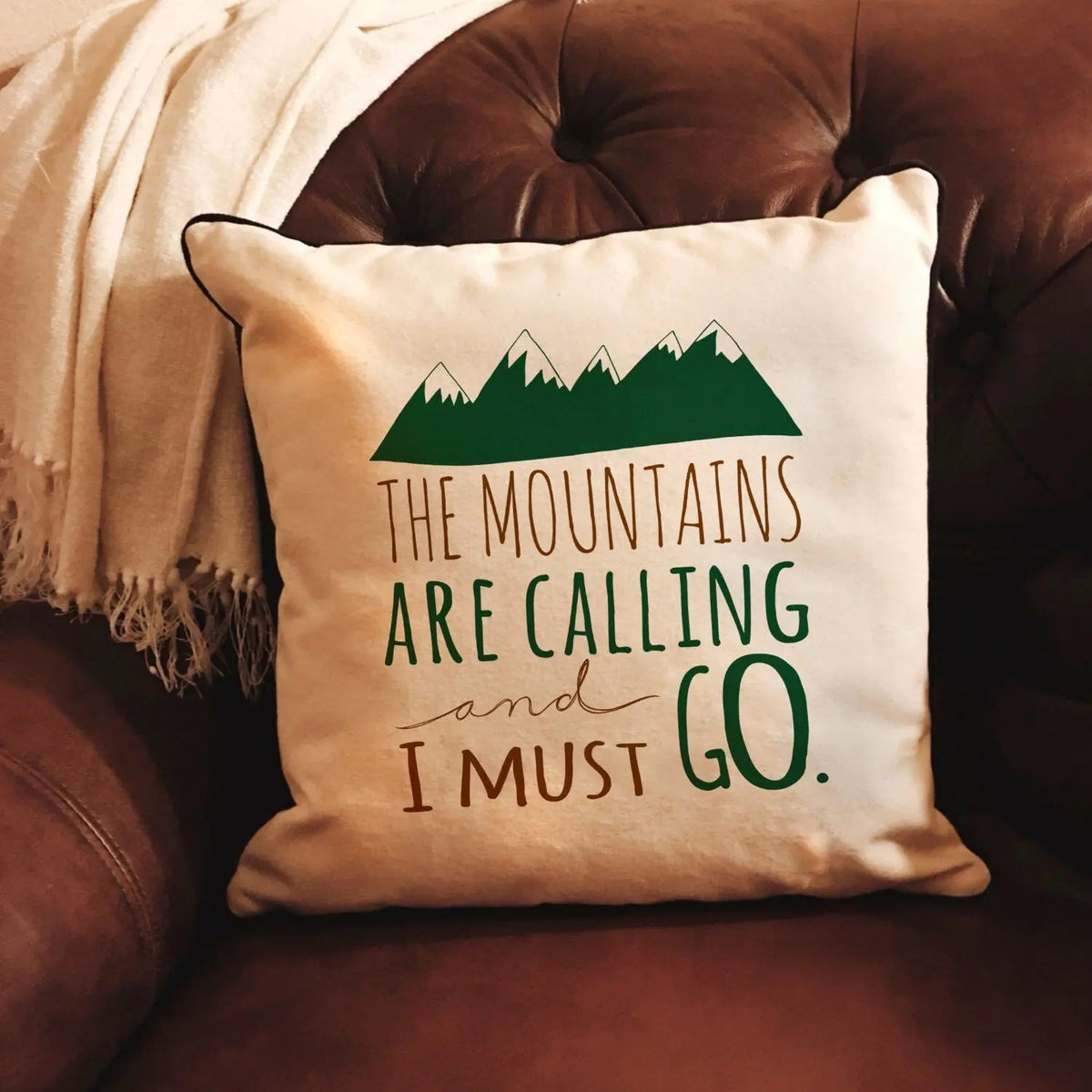 Natural pillow cover with green mountain graphic and 'I must go' quote