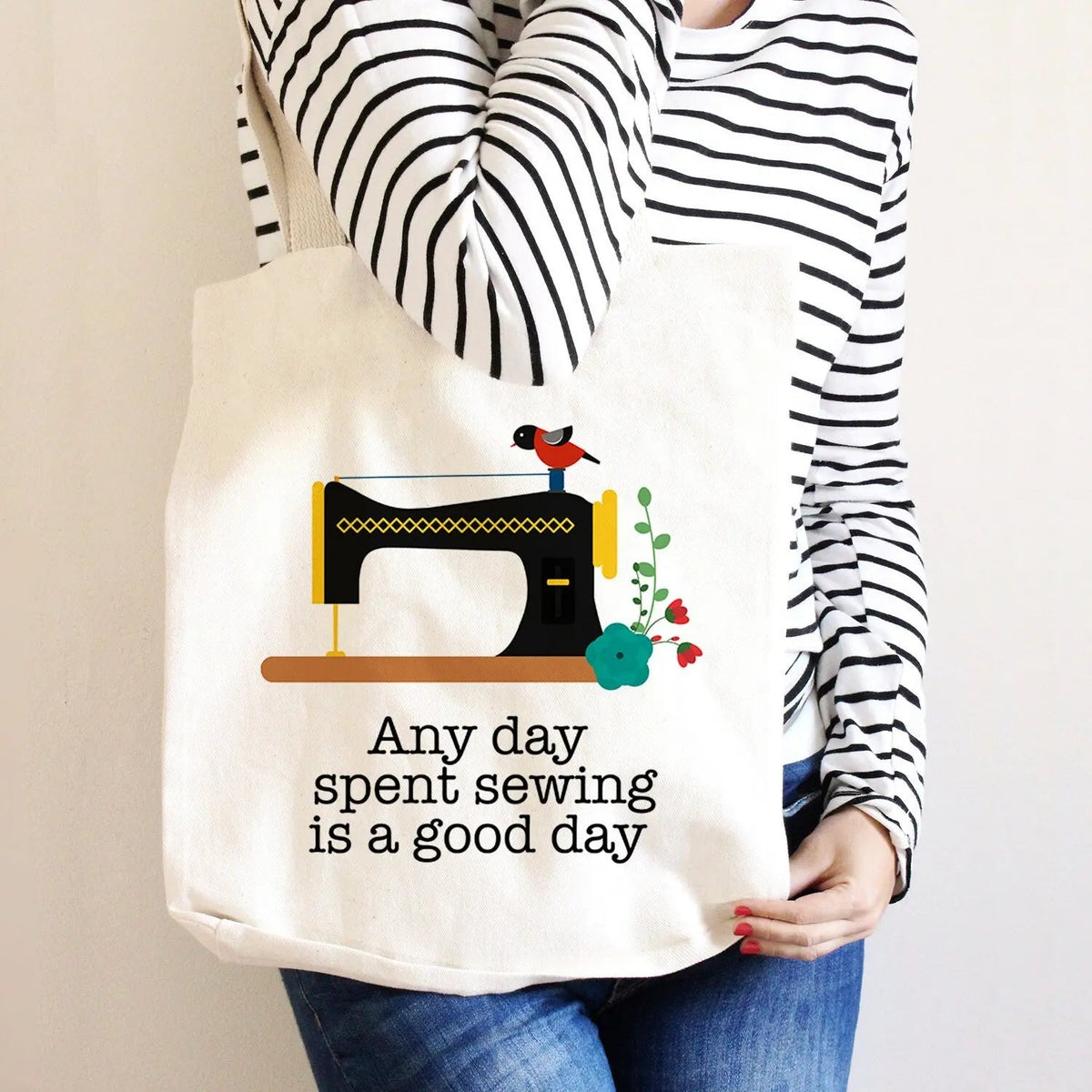 Off-white canvas tote bag with sewing machine graphic and text, red bird and flowers