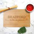 Personalized wood cutting board in light wood with engraved names and hearts