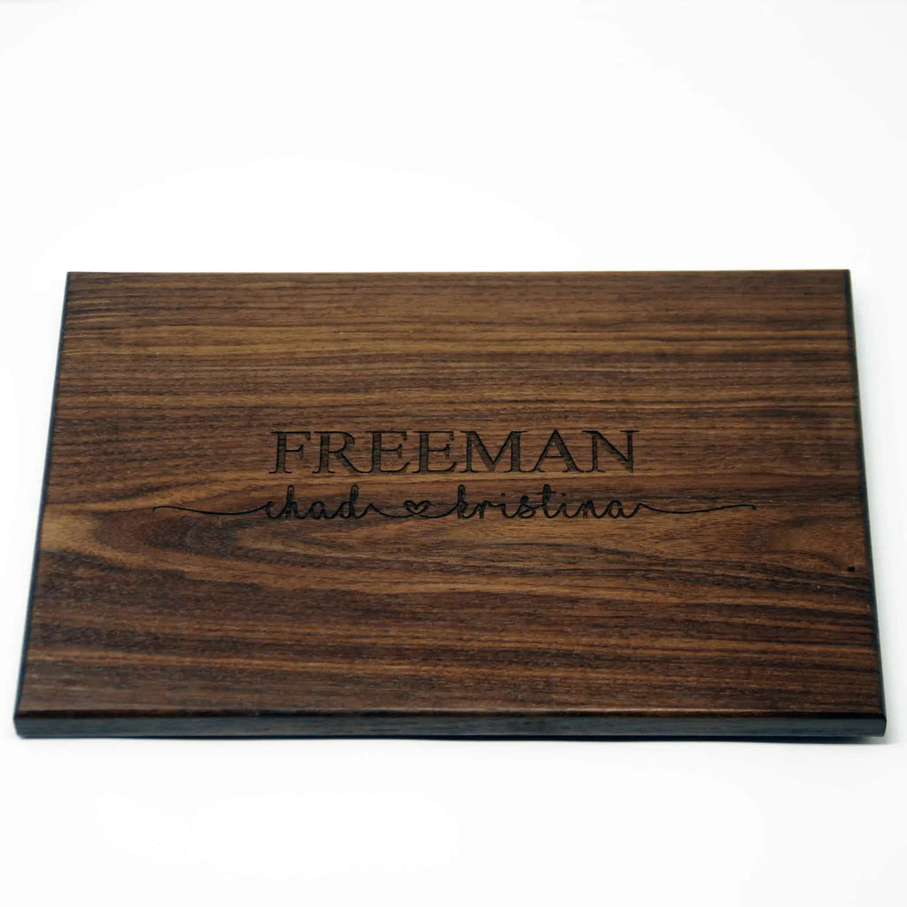 Personalized dark wood cutting board with engraved FREEMAN name and script