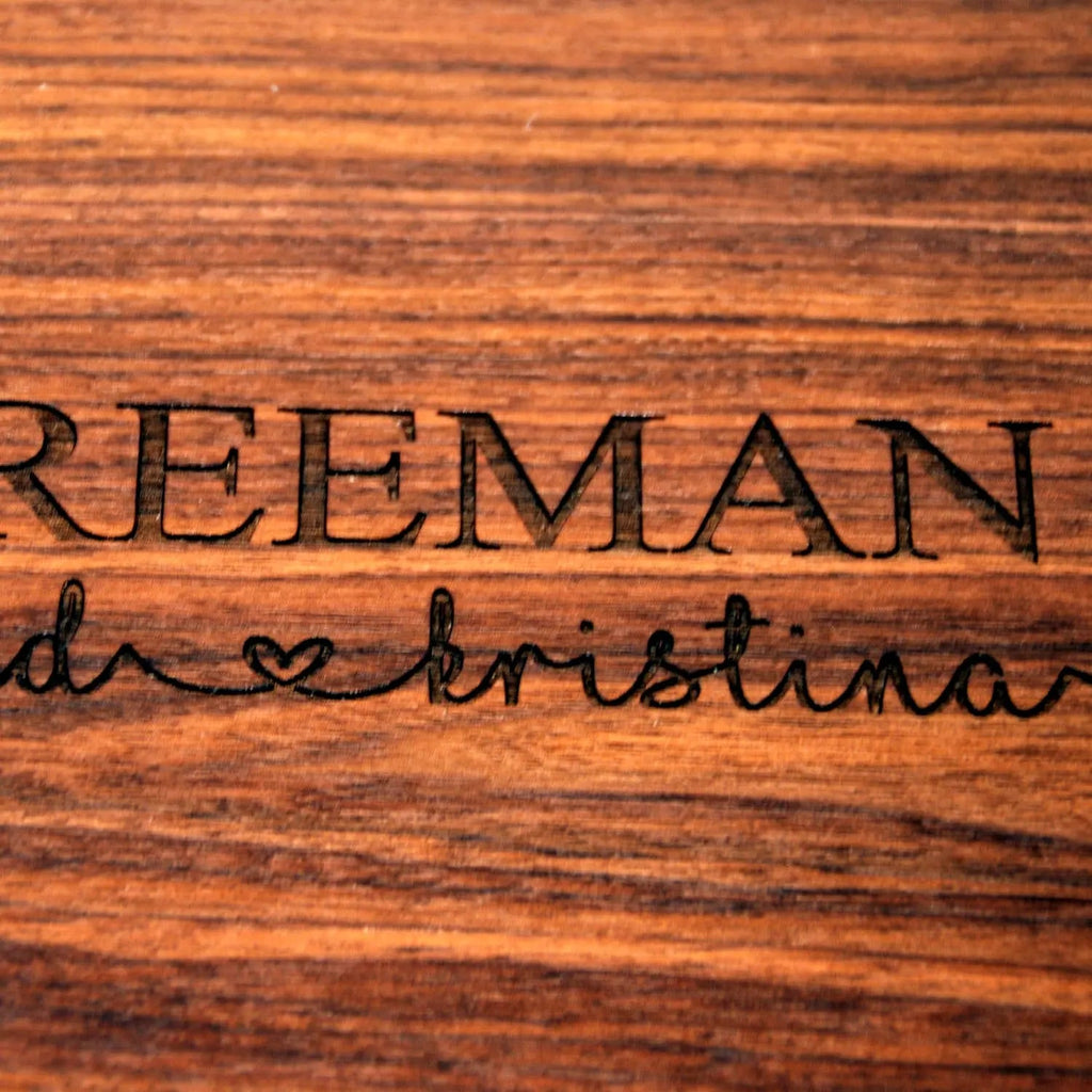 Close-up of engraved name and heart on a wood cutting board surface