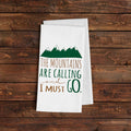 White kitchen towel with green mountain graphic and 'THE MOUNTAINS ARE CALLING' text