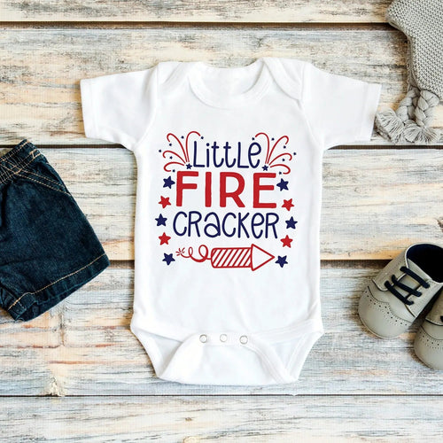 White infant bodysuit featuring “Little Fire Cracker” text and fireworks graphic