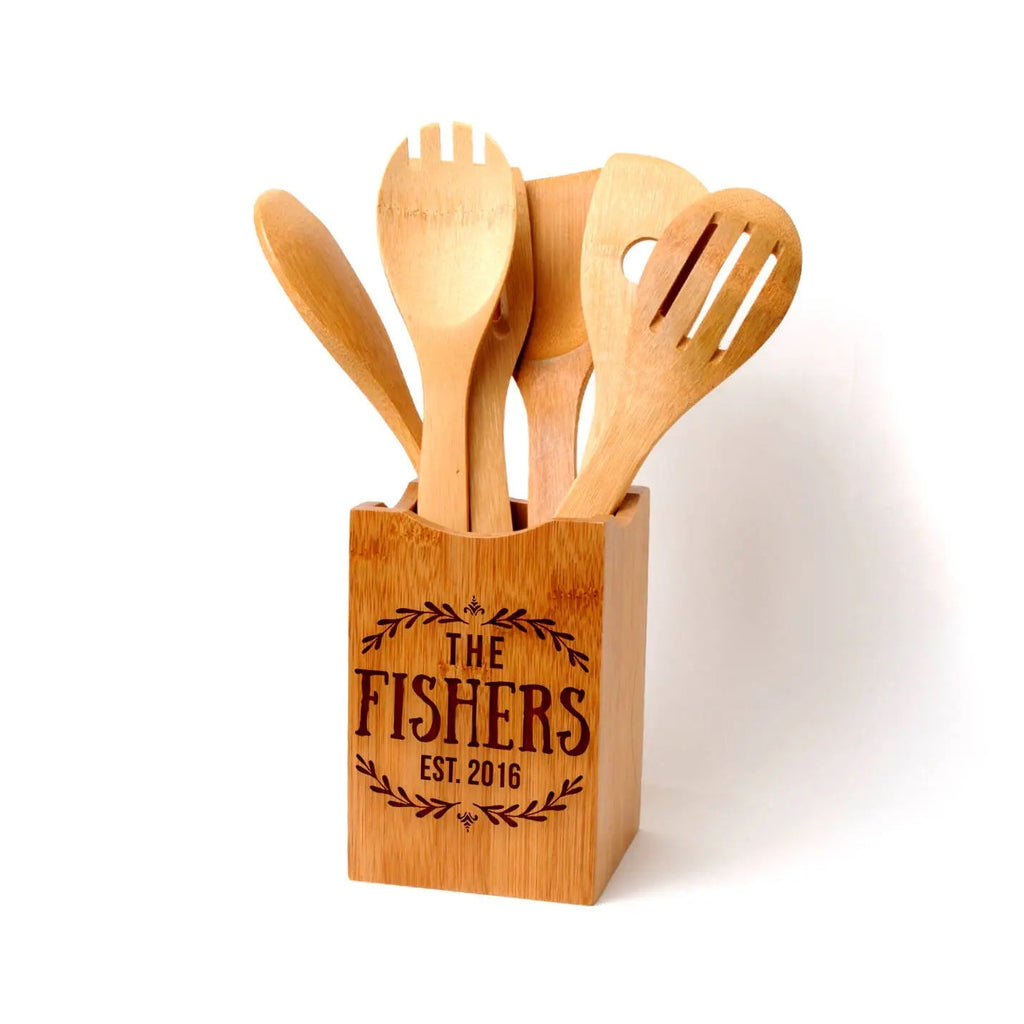 Bamboo kitchen utensil holder with carved logo and five wooden cooking utensils