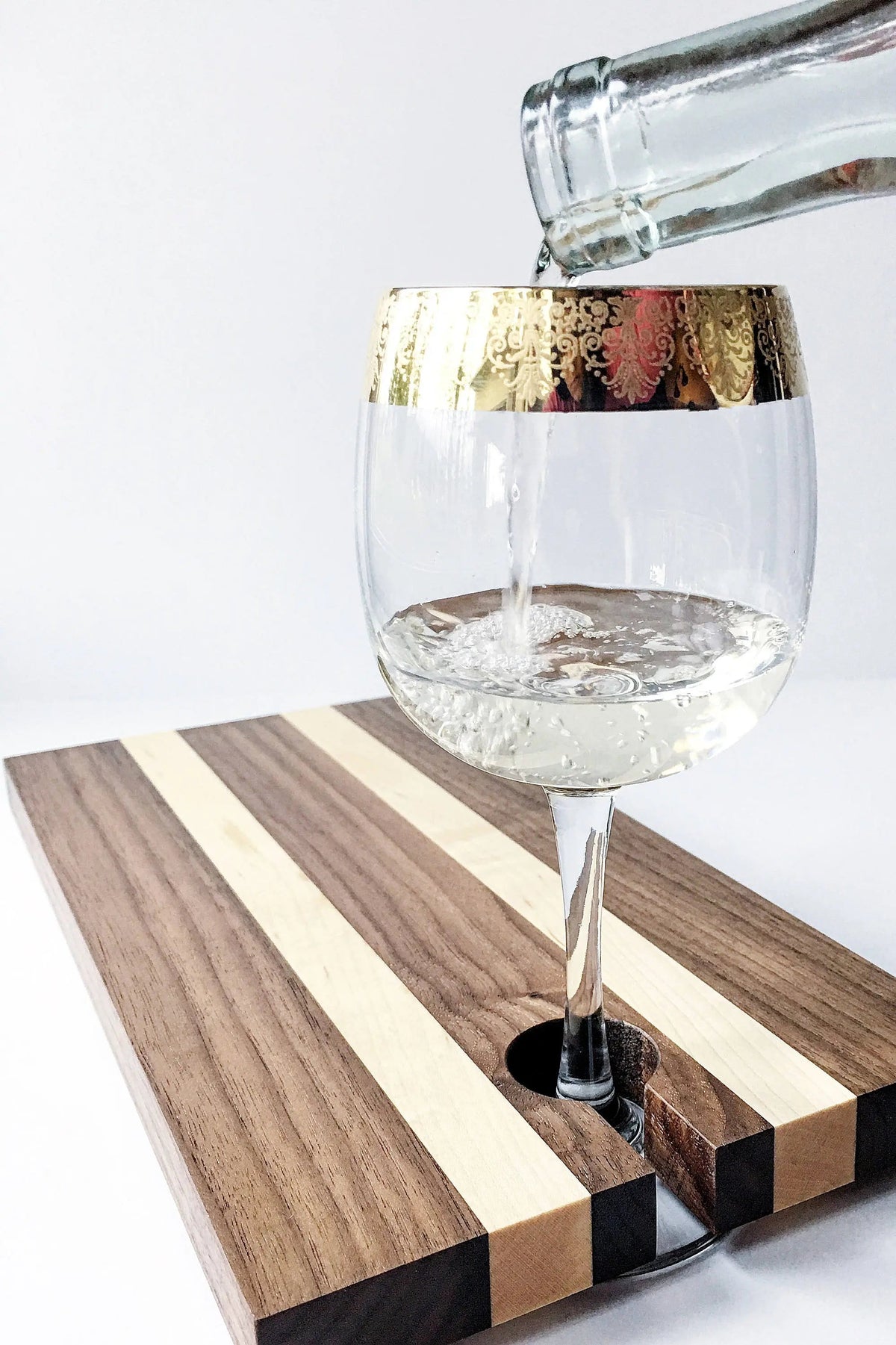 Striped wood charcuterie board with wine glass in built-in holder