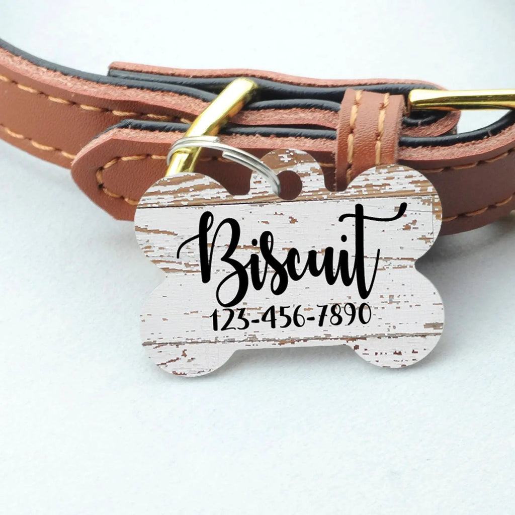 Wood-pattern bone pet ID tag attached to brown leather collar, engraved Bisquit and phone number