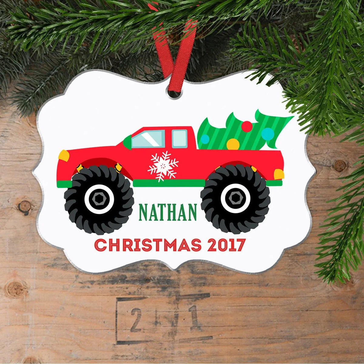 Monster truck Christmas ornament with red truck, snowflake accents, and name text
