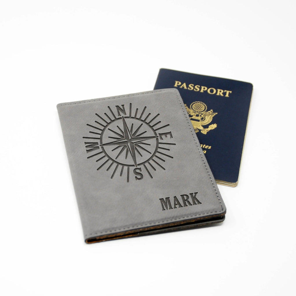 Gray faux leather passport holder with compass design and 'MARK' on the cover.