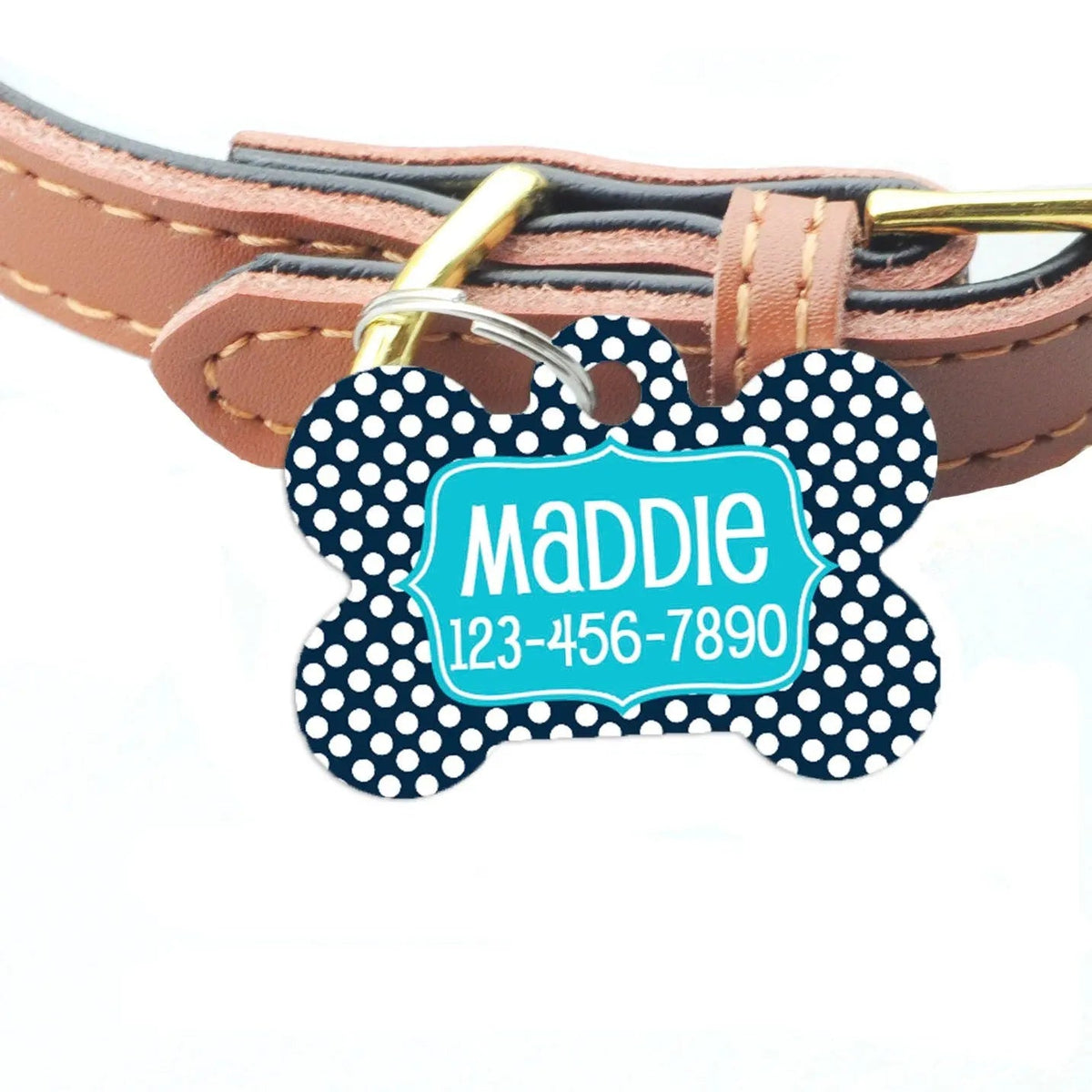 Navy bone-shaped ID tag with white dots attached to a brown pet collar