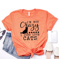Orange unisex t-shirt with black cat silhouette and text “I’m not Crazy, I just love cats”.
