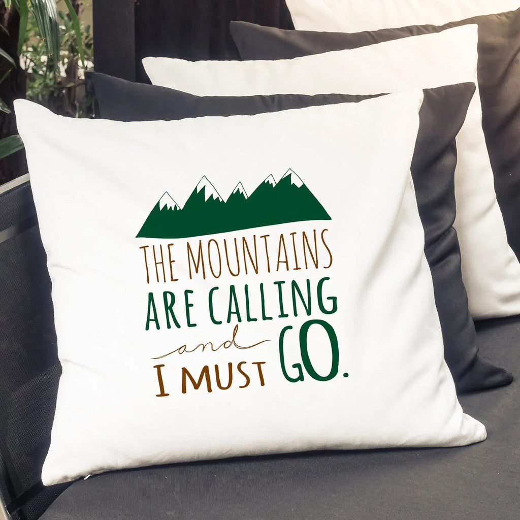 White pillow cover with green mountain graphic and quote 'The mountains are calling'