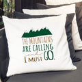 White pillow cover with green mountain graphic and quote 'The mountains are calling'