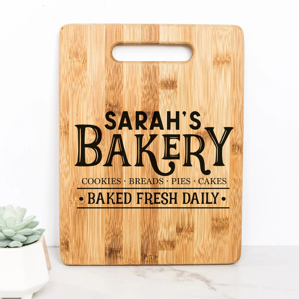 Light wood cutting board with handle, 'SARAH'S BAKERY' lettering