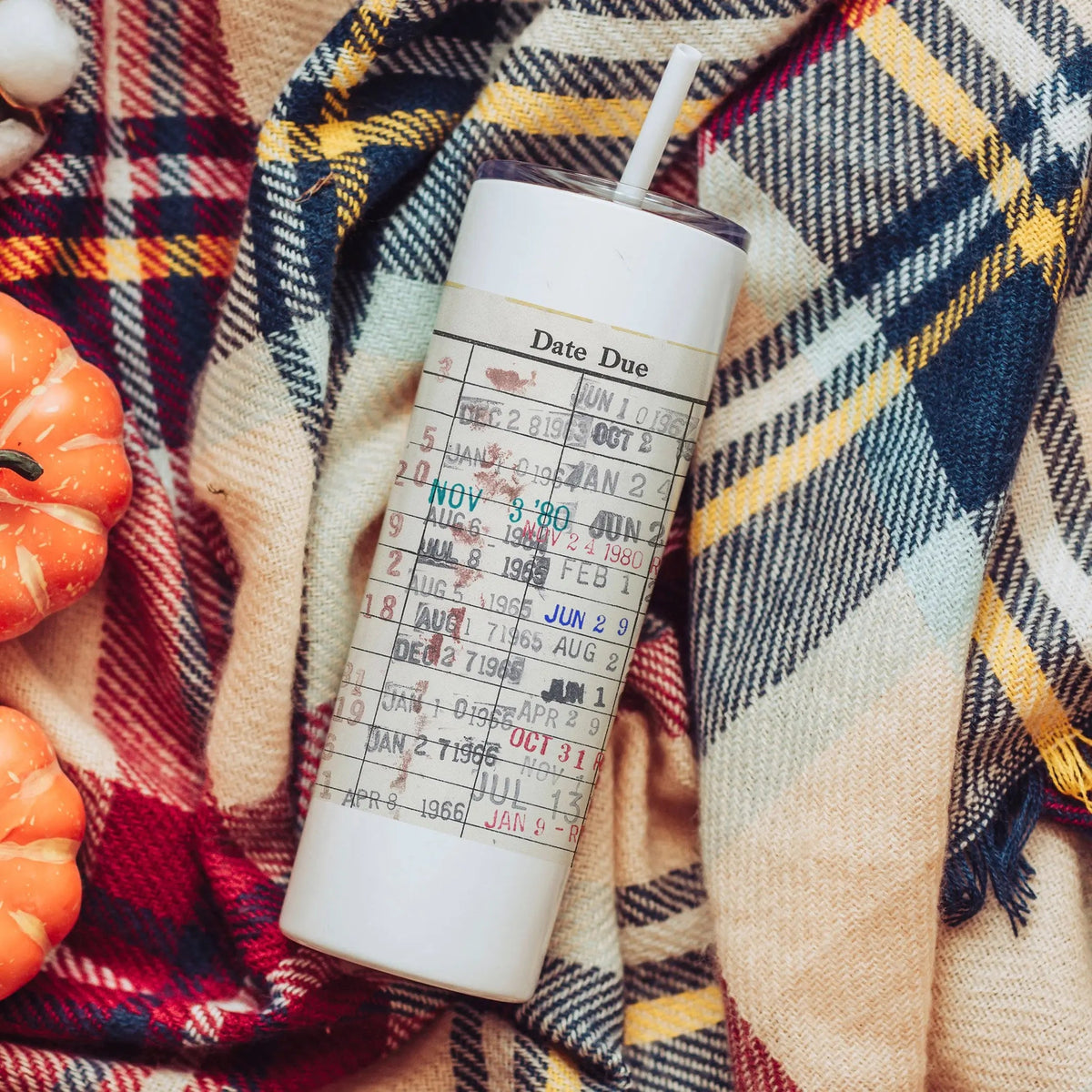 White insulated skinny water bottle tumbler with paper-style 'Date Due' label and straw.