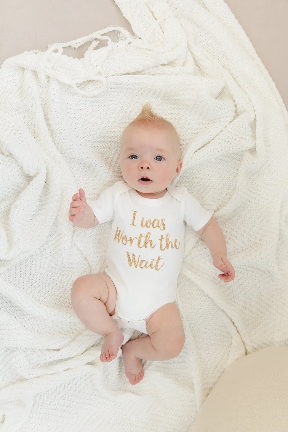 White newborn onesie with gold 'I was Worth the Wait' slogan