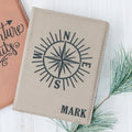 Passport holder in light faux leather with compass design and 'MARK' engraving.
