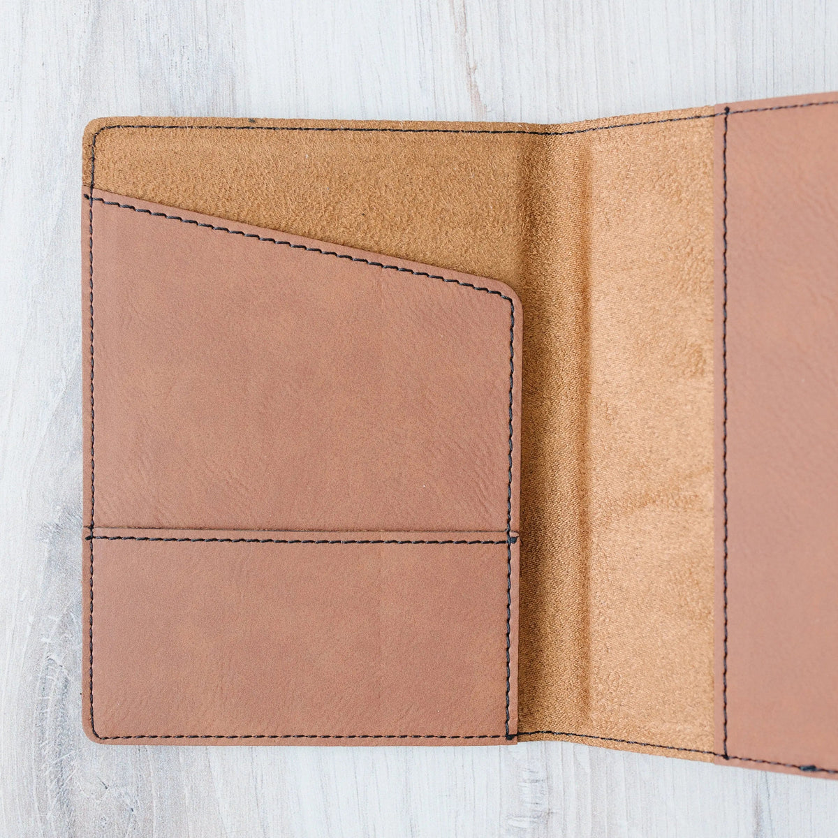 Interior of passport holder showing tan lining and stitched card pocket.