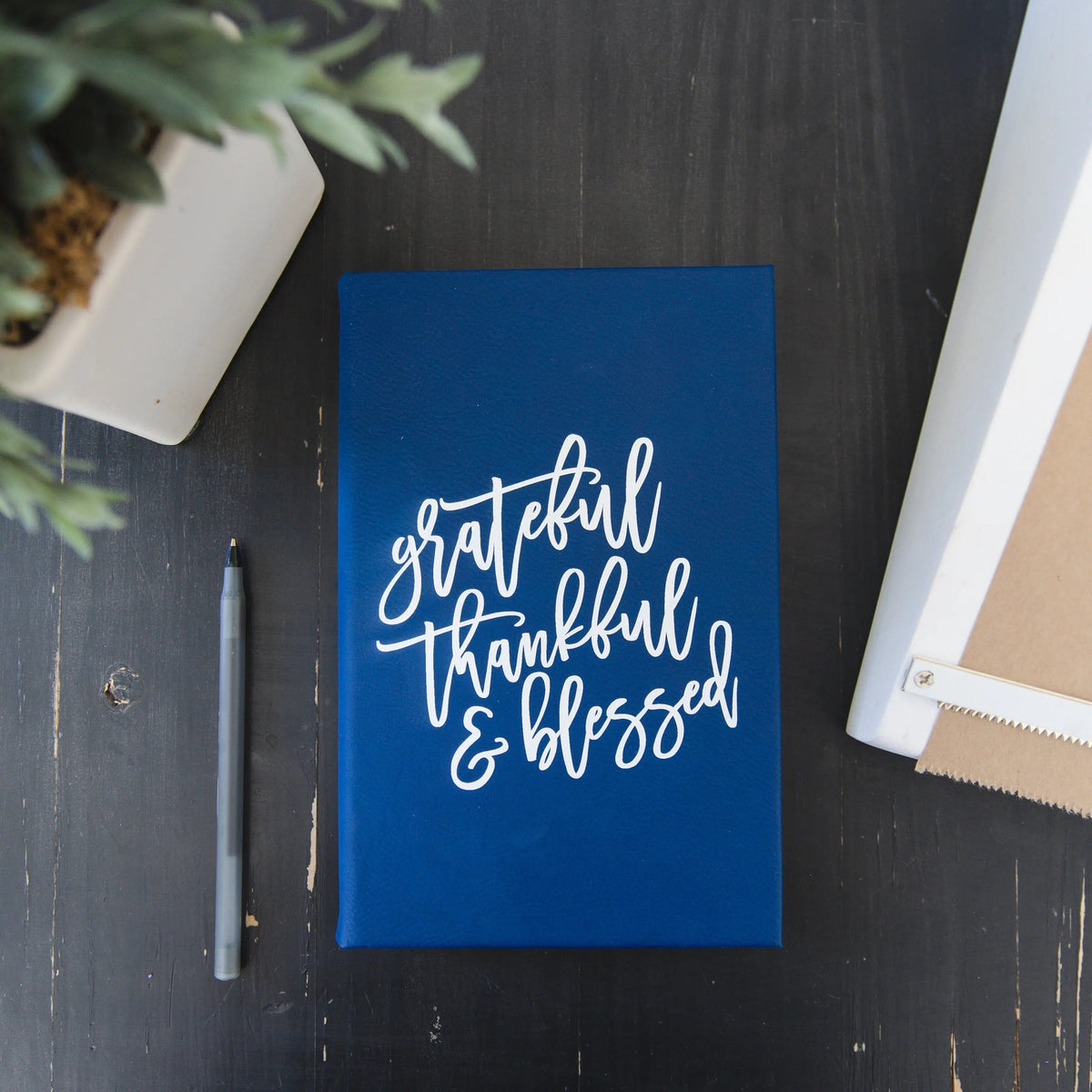 Blue gratitude journal front cover with white “grateful thankful & blessed” lettering