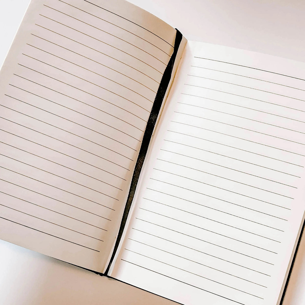 Open lined gratitude journal with ruled pages and black spine