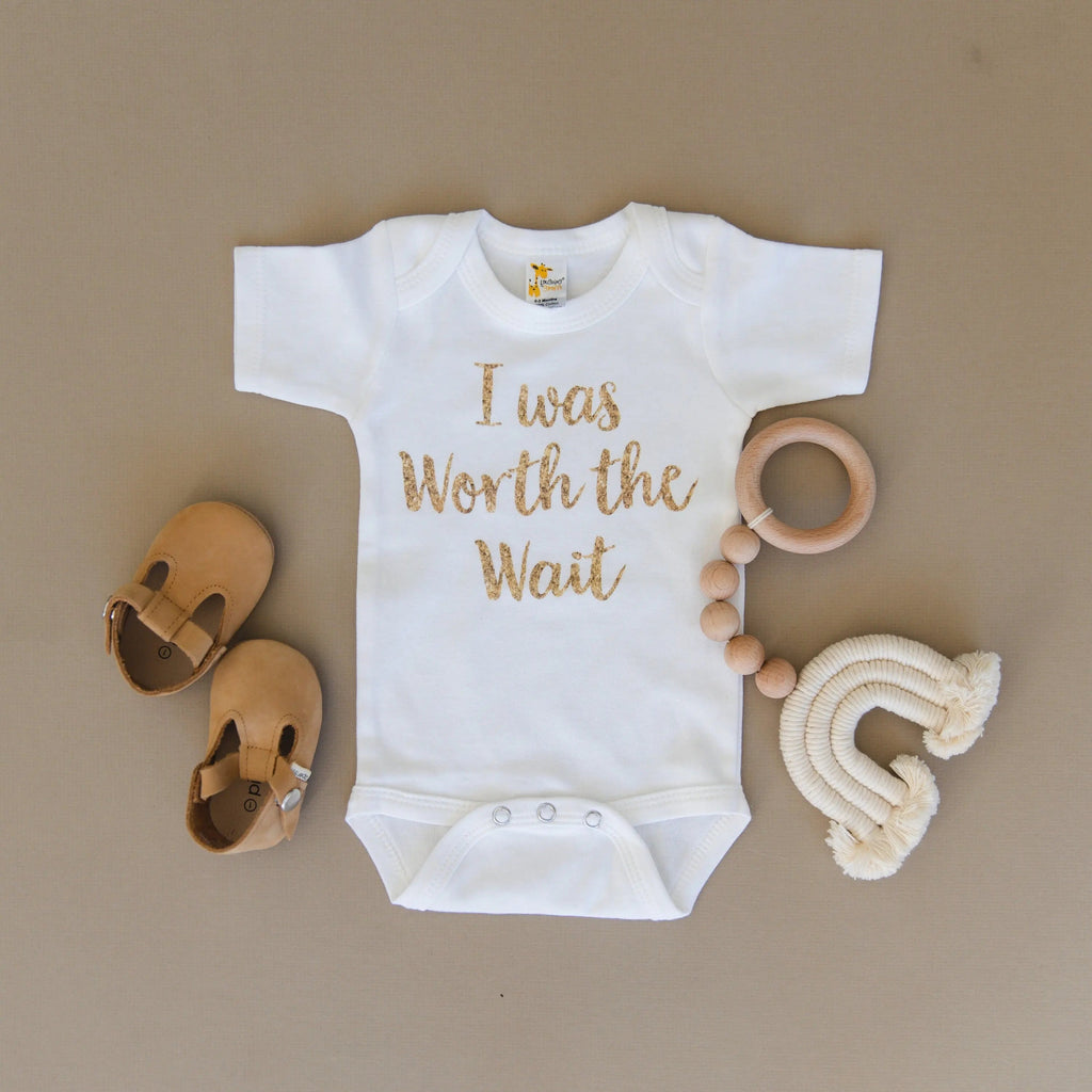 White newborn short-sleeve onesie with gold 'I was Worth the Wait' script
